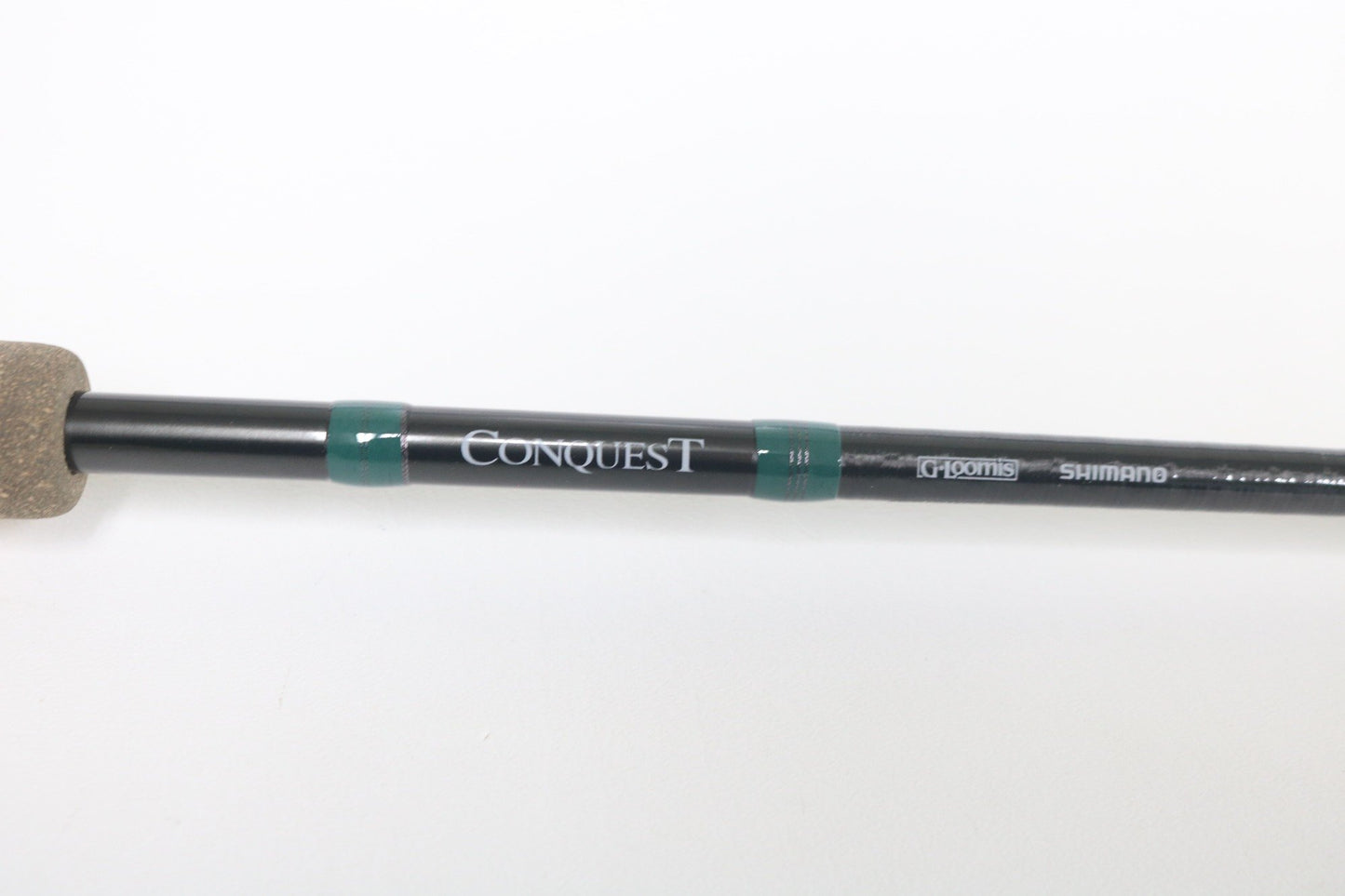 Close-up of a used G. Loomis Conquest CNQ 843C MBR Casting Rod in mint condition, displaying “Conquest” and G. Loomis branding on a white background. Trade in your gear for store credit with our Rod and Reel Trade-In Program.