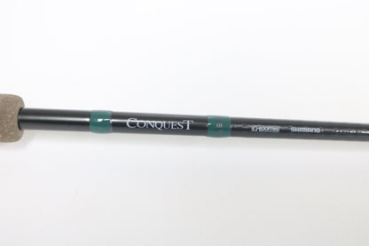 Close-up of a used G. Loomis Conquest CNQ 843C MBR Casting Rod in mint condition, displaying “Conquest” and G. Loomis branding on a white background. Trade in your gear for store credit with our Rod and Reel Trade-In Program.