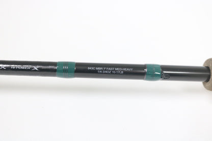 Close-up of the G. Loomis Conquest CNQ 843C MBR Used Casting Rod in mint condition, featuring white specs on a black rod with green accents and cork handle—ideal for our Trade-In Program to earn store credit on used gear.