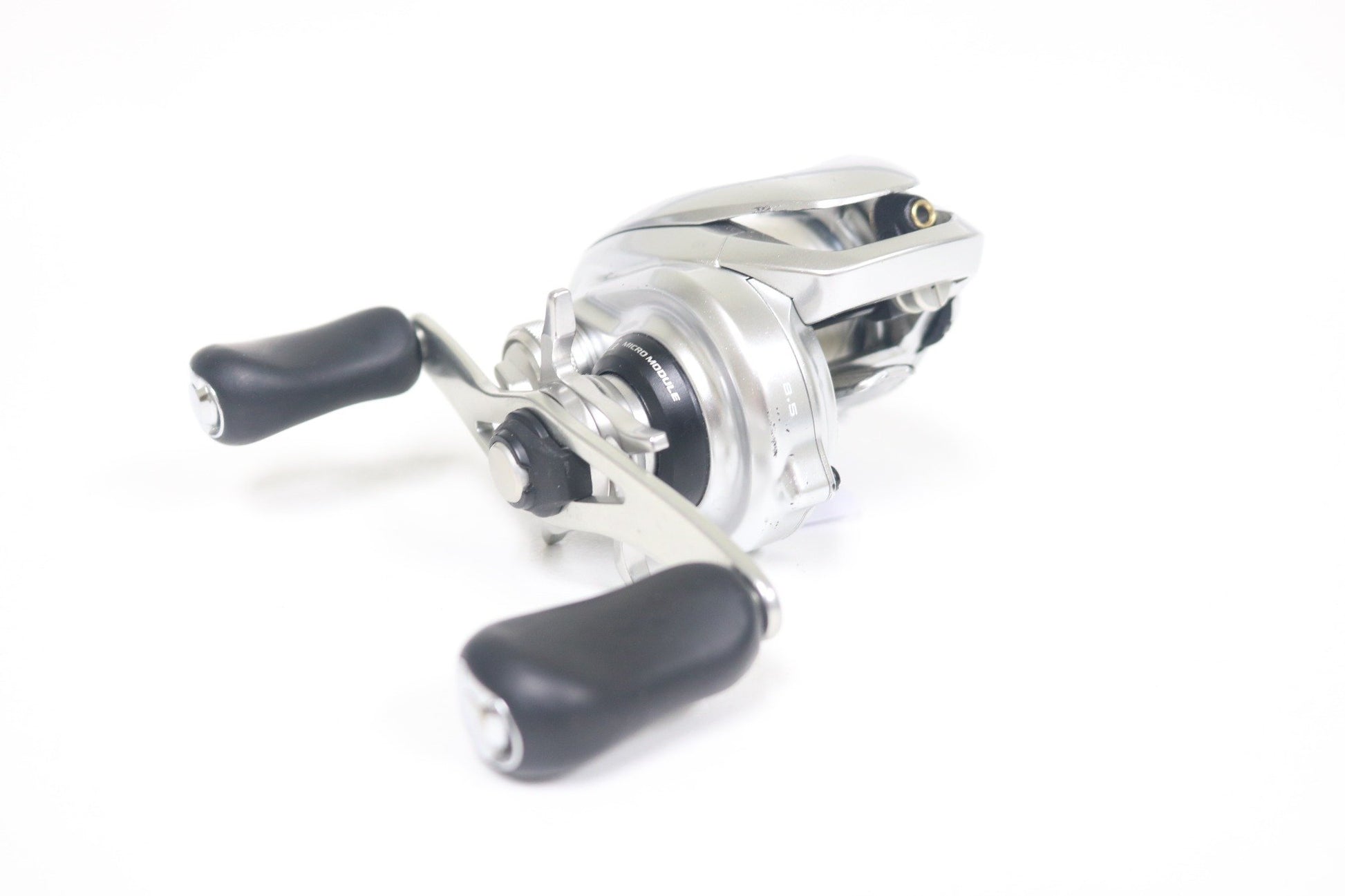 A close-up of a Shimano Metanium MGL 150XG 8:5:1 used casting reel in very good condition, featuring black rubber handles on a white background—ideal for anglers using our Used Gear and Rod and Reel Trade-In Program.