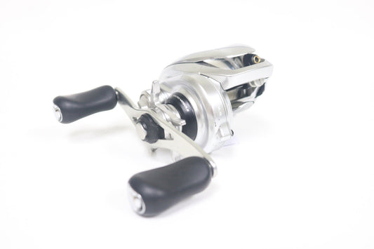 A close-up of a Shimano Metanium MGL 150XG 8:5:1 used casting reel in very good condition, featuring black rubber handles on a white background—ideal for anglers using our Used Gear and Rod and Reel Trade-In Program.