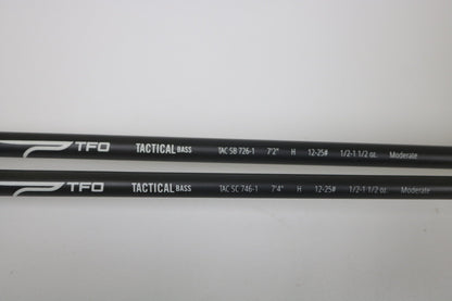 Two black Temple Fork TFO Tactical Bass TAC SB 726-1 and TAC SC 746-1 casting rods (used, good condition) are side by side on a white surface with white specs. Trade in used gear for store credit through our Rod and Reel Trade-In Program!.