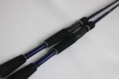 Two Douglas LRS C704M Casting Rods—used, in very good condition—are placed parallel on a white surface, ideal for those interested in quality used gear or our Rod and Reel Trade-In program.