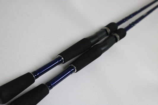 Two Douglas LRS C704M Casting Rods—used, in very good condition—are placed parallel on a white surface, ideal for those interested in quality used gear or our Rod and Reel Trade-In program.