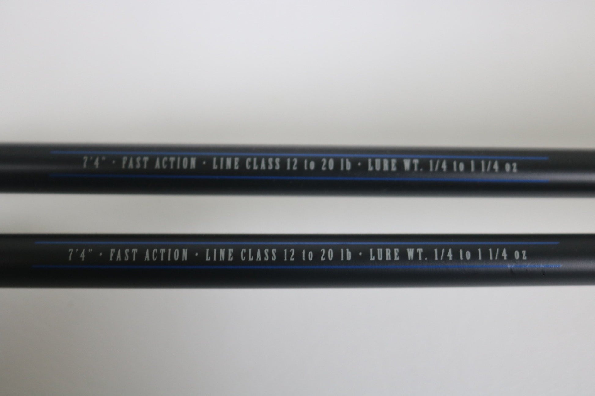 Two black Mustad BLF Instinct 7'4" Medium Heavy Casting Rods (used, very good) feature white text specs on the shafts—ideal for those trading in used gear through the Nation's Best Rod and Reel Trade-In Program.