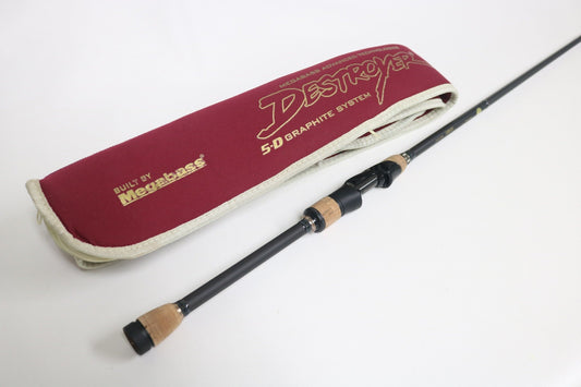 A Megabass Destroyer P5 Landsat F3-611XS 6'11" spinning rod with a wooden handle rests beside its maroon cloth sleeve featuring gold "Destroyer 5D Graphite System" and "Built by Megabass" text on a white background. (Used, Excellent Condition).