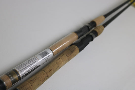 Two Fenwick Techna Av AVC79HF and AVC71HF Casting Rods in very good used condition are shown side by side on a white surface, one with a barcode label for the Rod and Reel Trade-In Program; both display authentic worn cork handles.