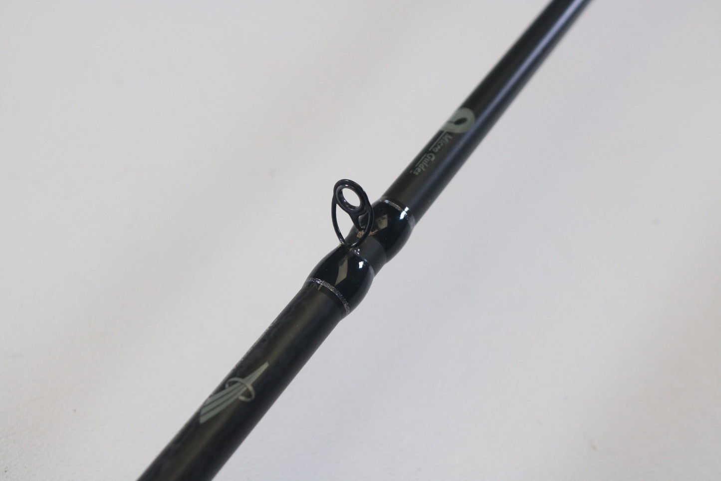 A close-up of a Waft Iron Feather 7'0" Medium Heavy used casting rod, highlighting a line guide against a white background—ideal for evaluating gear condition before a Rod and Reel Trade-In.