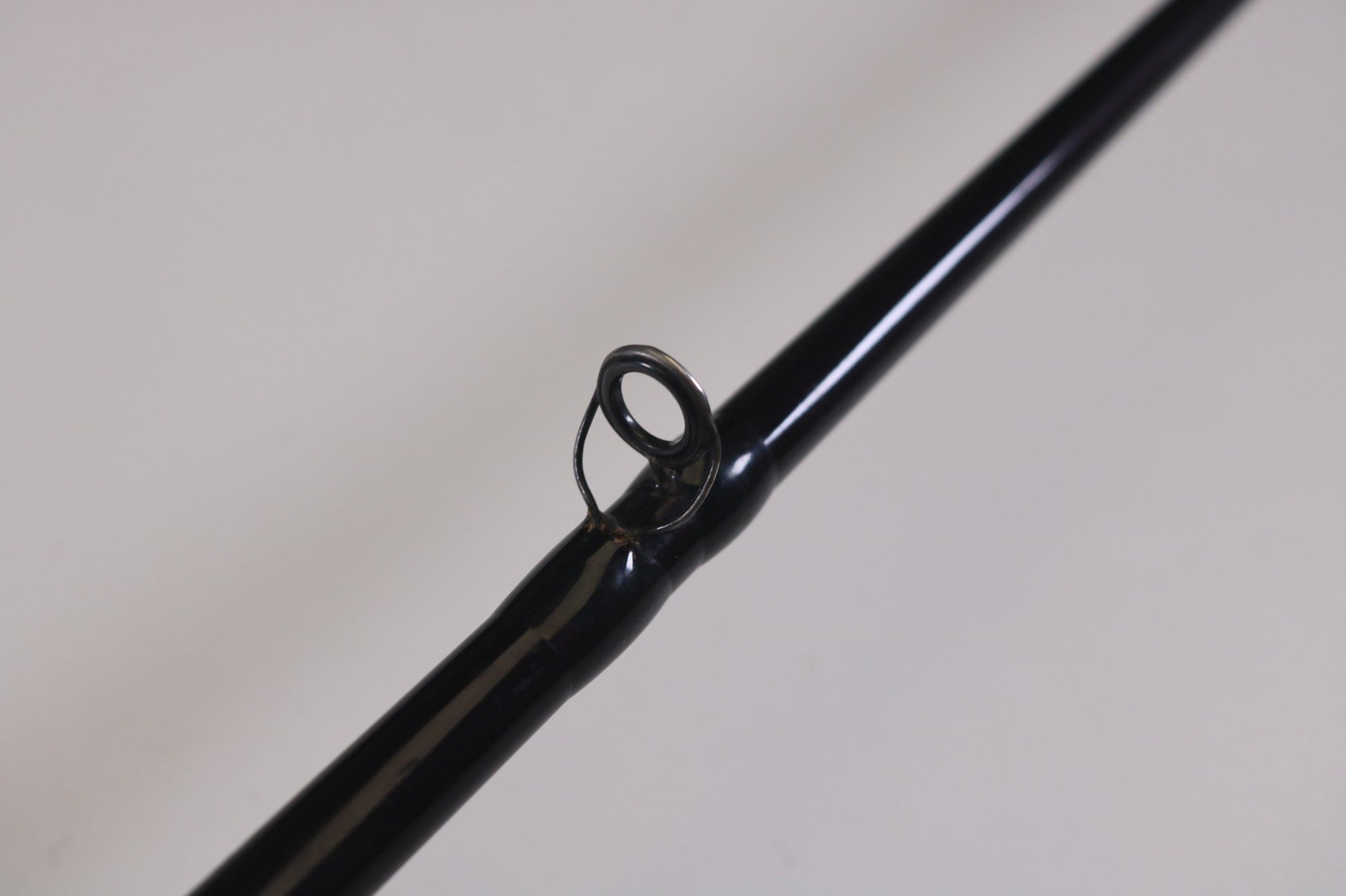 Close-up of a black St. Croix Mojo Bass MJC71MF 7'1" Medium used casting rod in very good condition, featuring a single line guide against a light background. Ideal for upgrades through the Rod and Reel Trade-In Program to earn extra store credit with your used gear.