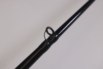 Close-up of a black St. Croix Mojo Bass MJC71MF 7'1" Medium used casting rod in very good condition, featuring a single line guide against a light background. Ideal for upgrades through the Rod and Reel Trade-In Program to earn extra store credit with your used gear.