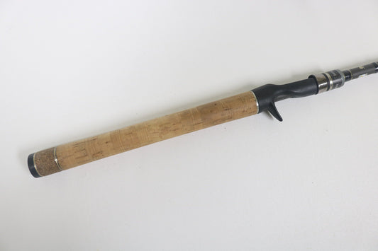A close-up of the Dobyns Xtasy DRX 755C 7'5" Mag Heavy used casting rod handle, featuring a cork grip and black reel seat—ideal for trading in through our Rod and Reel Trade-In Program for store credit.