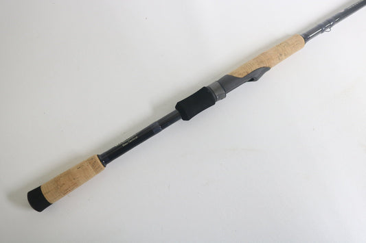 The St. Croix Victory VTS73MXF Used Spinning Rod, in excellent condition, features cork handles, a black reel seat, and a graphite body. It is shown lying diagonally on a white background.