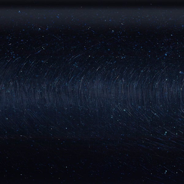 A dark, reflective surface featuring faint swirling lines and speckles of light captures the essence of the St. Croix Premier 6'0" Medium Light Spinning Rod | PS60MLF from American Legacy Fishing against a starry sky. This imagery mirrors deep space or a serene night sky with subtle textures, combining cosmic allure with precision.