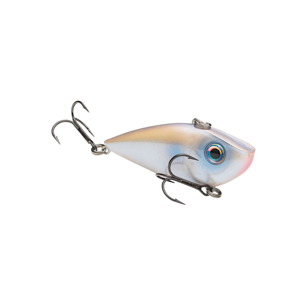 The Strike King Red Eye Shad by Strike King is a lipless crankbait with a metallic fish-shaped body, blue and pink shading, realistic eyes, and premium hooks that mimics live bait to attract fish effectively.