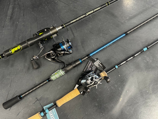 Two Shimano Teramar South East Spinning rods (TMS80M) in mint condition are laid out, one with a black handle and yellow logo, the other with a cork handle and blue accents. Both spinning reels are attached and display product tags.